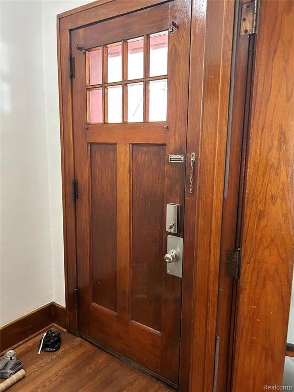 Doorway to outside with wood finished floors and baseboards