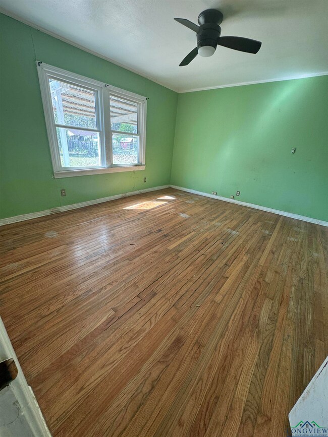 Spare room featuring baseboards, wood finished flo