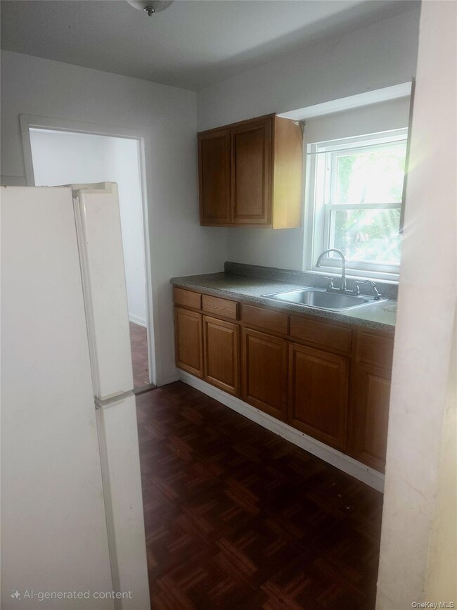 Kitchen featuring freestanding refrigerator and brown cabinets