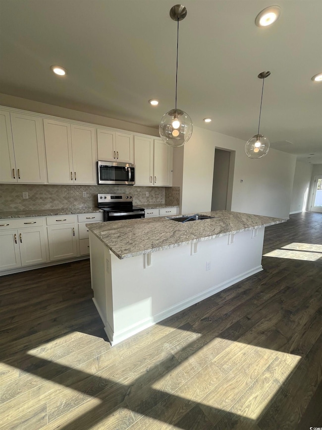 Kitchen featuring pendant lighting, white cabinets