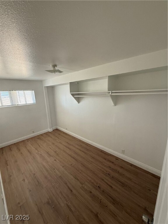 Unfurnished bedroom with wood finished floors, a t