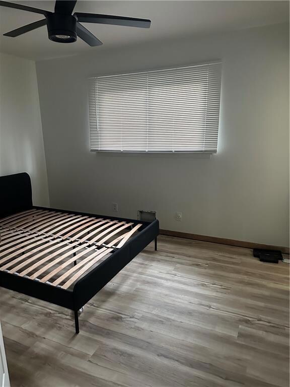 Bedroom with ceiling fan and light hardwood / wood-style floors