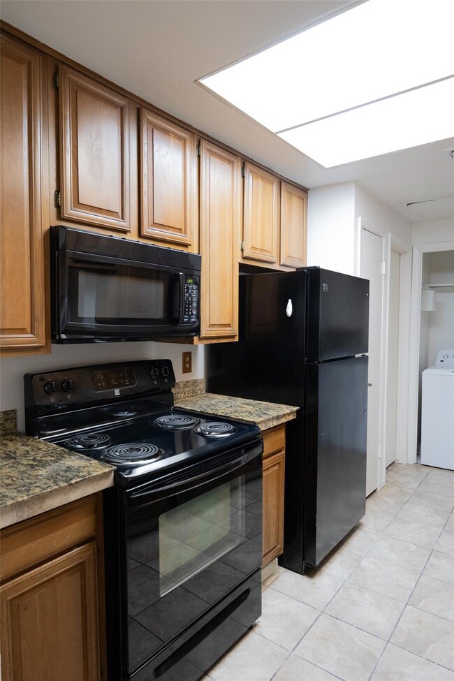 Kitchen featuring washer / dryer, light tile patt