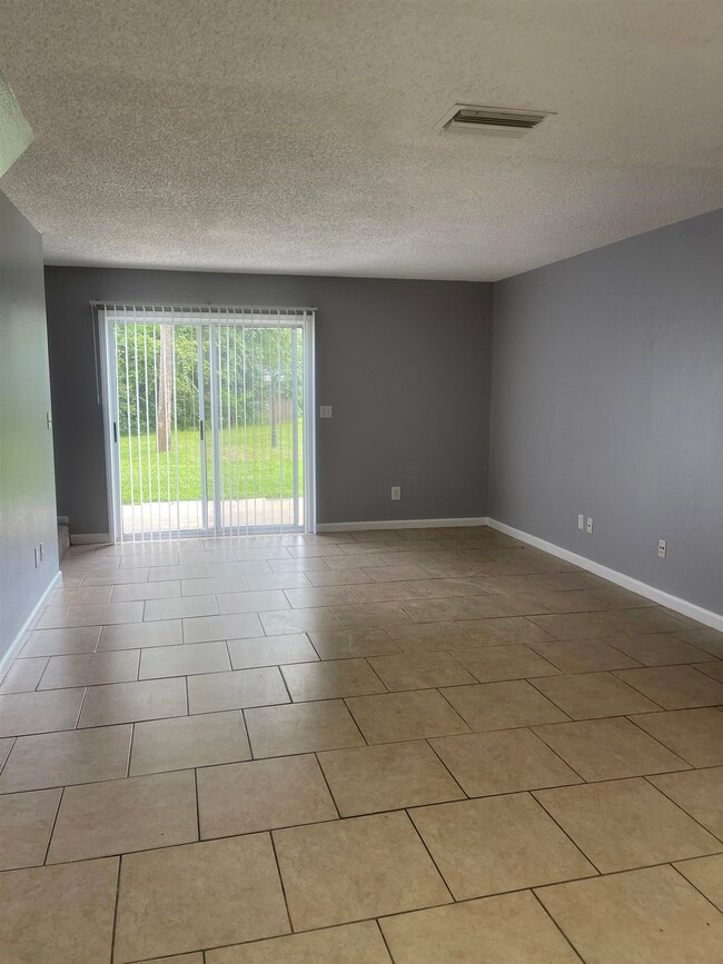 Spare room with a textured ceiling and light tile patterned flooring