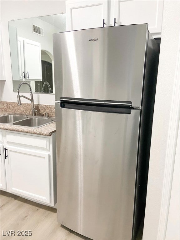 Kitchen featuring freestanding refrigerator, a sin