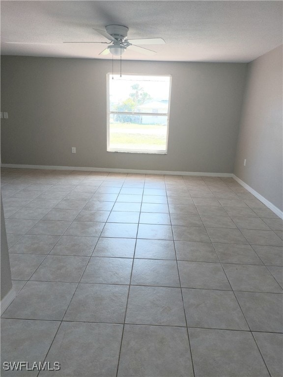 Spare room featuring a ceiling fan, baseboards, an