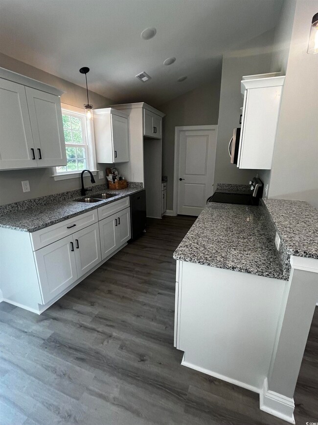 Kitchen featuring hanging light fixtures, sink, da