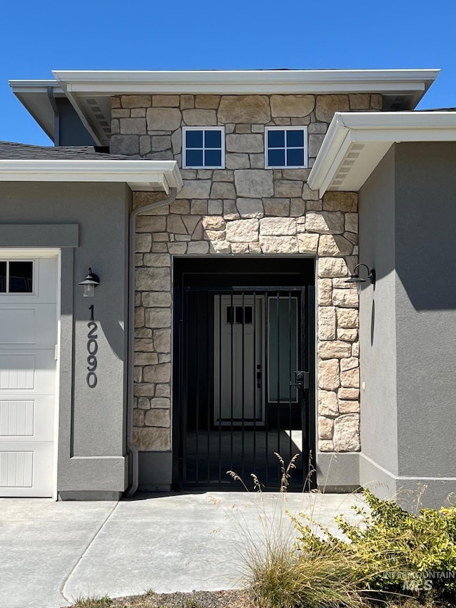 Doorway to property featuring stone siding and stucco siding