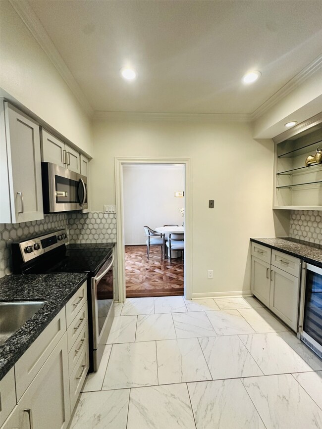 Bright kitchen features sleek cabinetry, wine frid