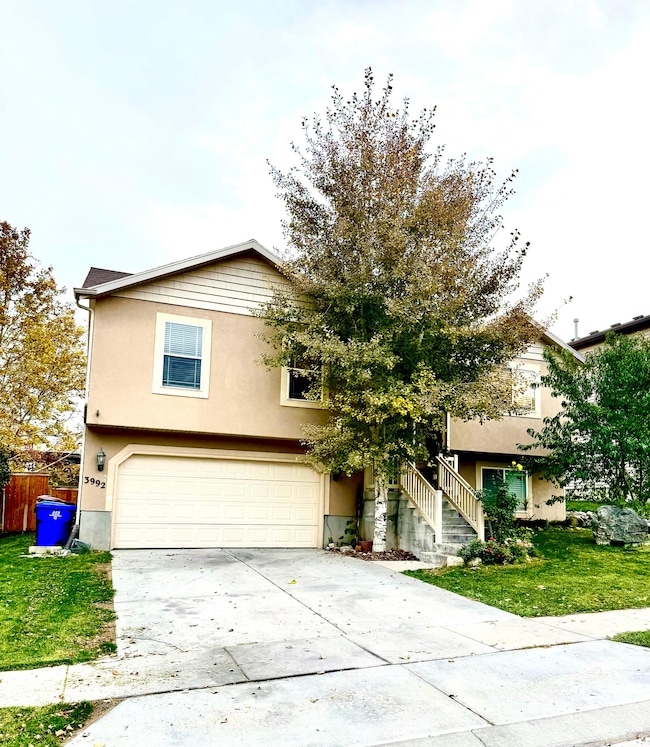 View of front facade featuring driveway, stucco siding, and a garage