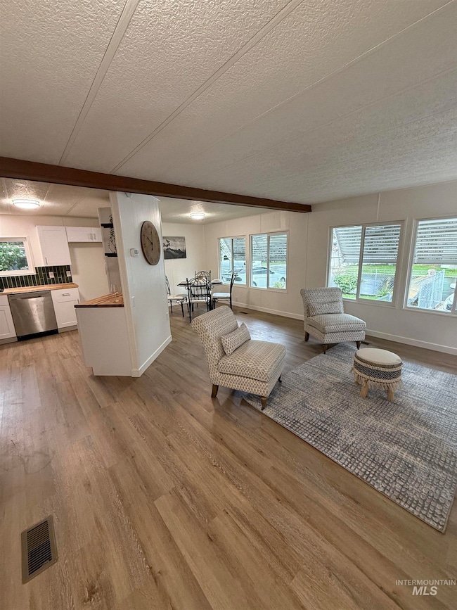 Living room featuring light wood finished floors and a textured ceiling