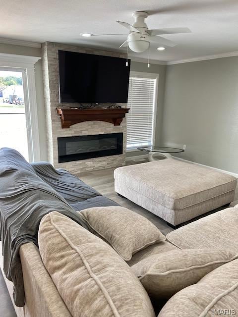 Living area with ornamental molding, a large fireplace, ceiling fan, wood finished floors, and a textured ceiling