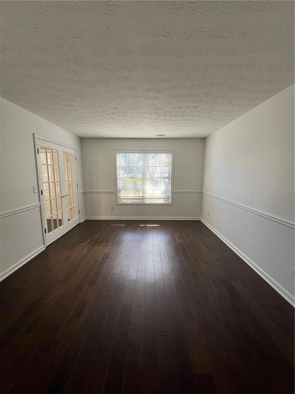 Spare room with dark wood finished floors and a textured ceiling