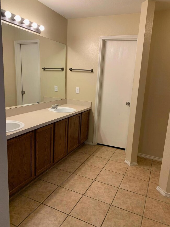 Bathroom featuring double sink vanity and tile flo