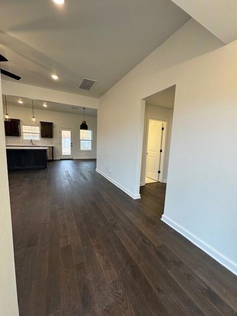 Unfurnished living room featuring dark hardwood / 
