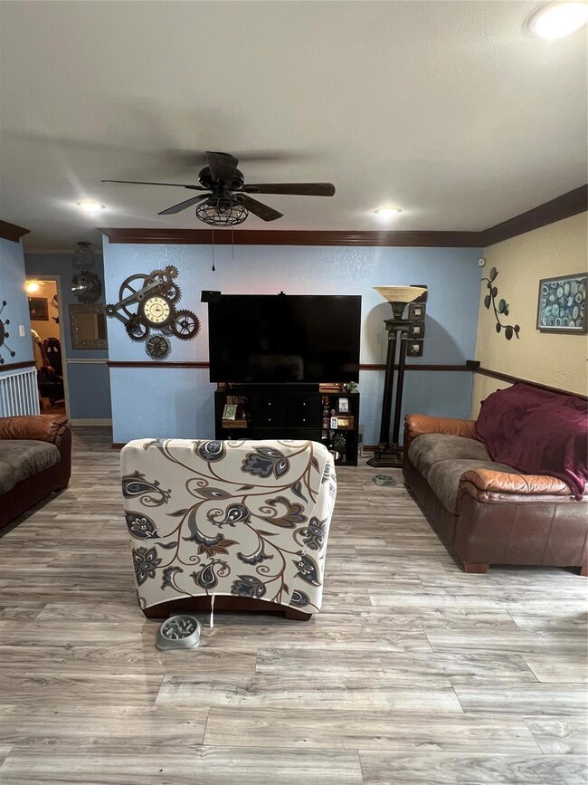 Living area with a ceiling fan, ornamental molding