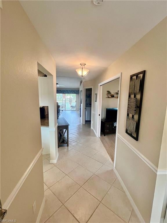 Corridor with light tile patterned floors and base