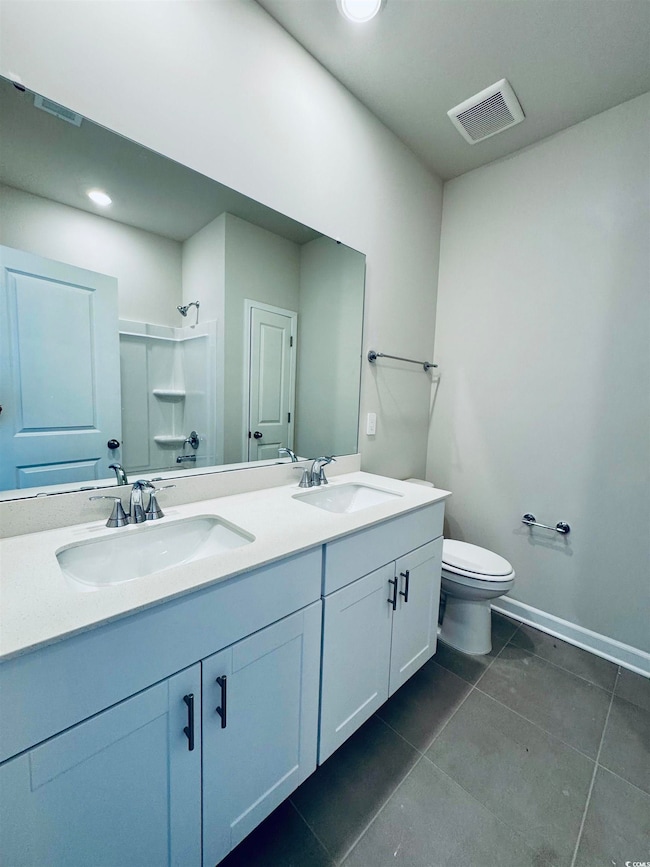 Bathroom with visible vents, a sink, toilet, and a shower