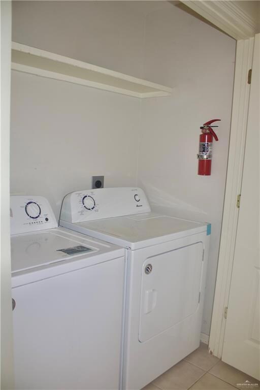 Laundry room featuring washer and dryer and light tile patterned floors