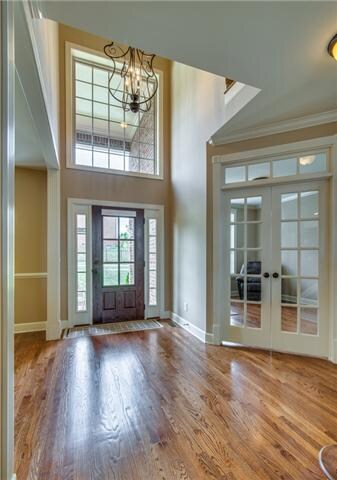 The spacious 2-Story Foyer welcomes you with a 6-light glass door, beautiful iron chandelier and hardwood floors flowing through an open floor plan.  
