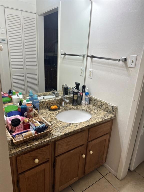 Bathroom featuring vanity, tile patterned floorin