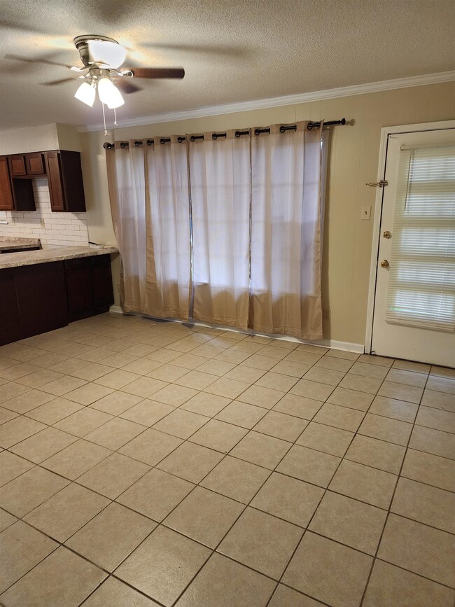 Interior space with ceiling fan, light tile floors