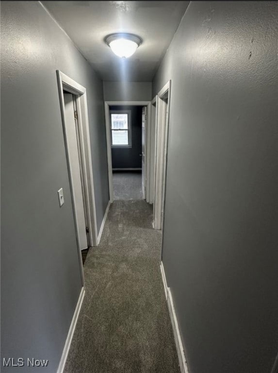 Hall featuring carpet and baseboards