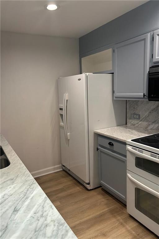 Kitchen with gray cabinetry, light wood-type floor