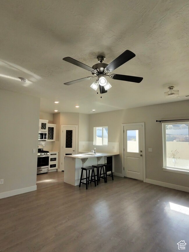 Dining room featuring dark wood-style flooring and ceiling fan