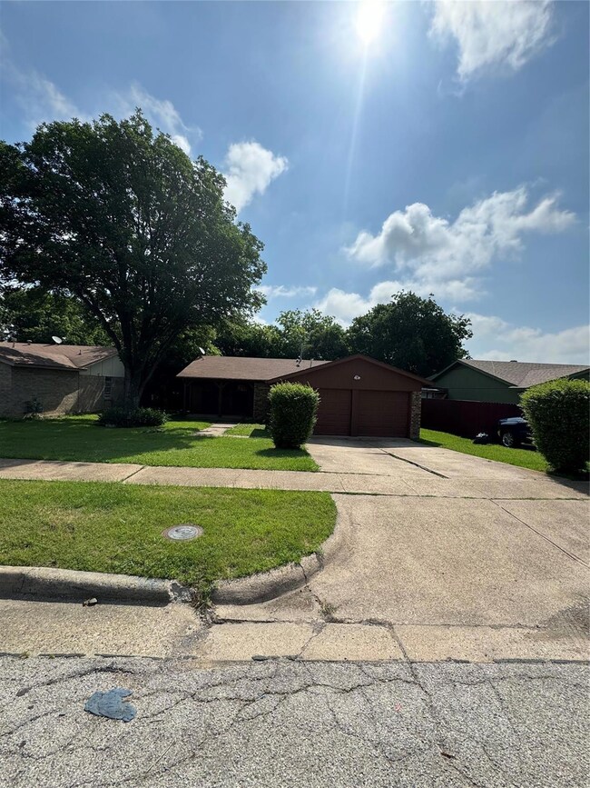 Ranch-style home with a garage and a front yard