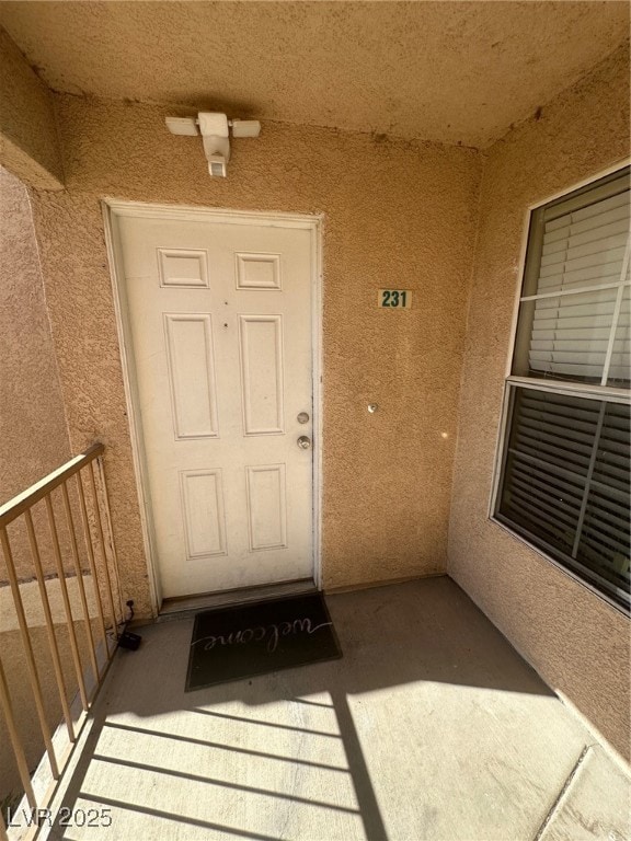 Property entrance featuring stucco siding