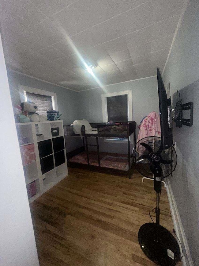 Bedroom featuring wood finished floors and baseboards