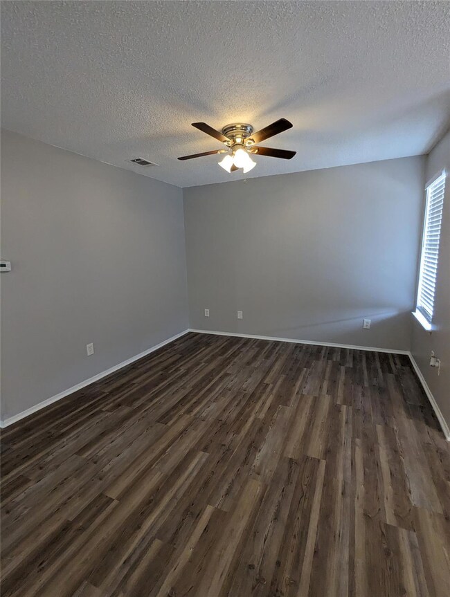 Spare room with dark wood finished floors, a text