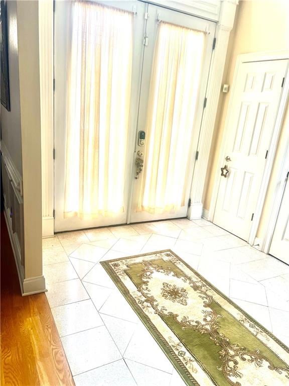 Tiled foyer entrance with baseboards