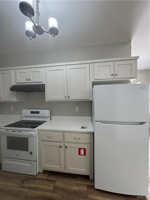 Kitchen featuring white cabinetry, refrigerator, ventilation hood, and range