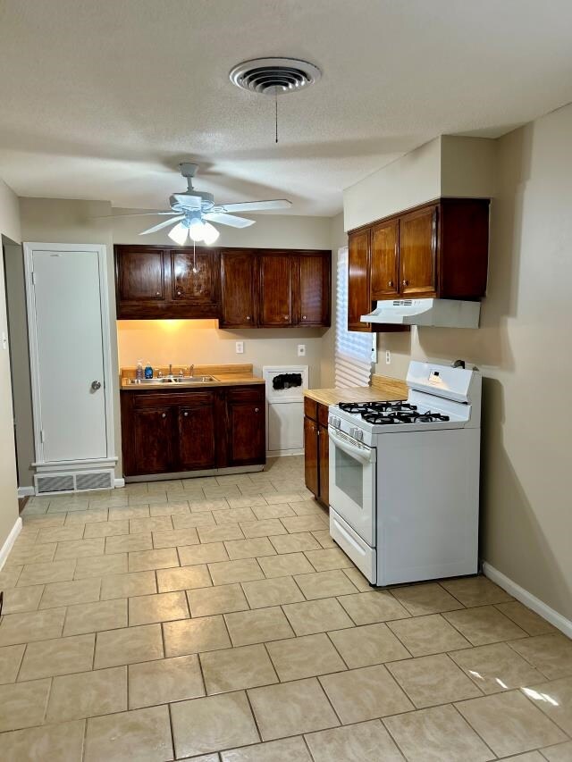 Kitchen featuring a textured ceiling, white gas st