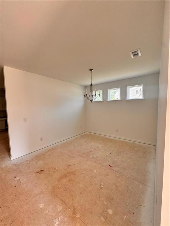 Unfurnished room with a chandelier
