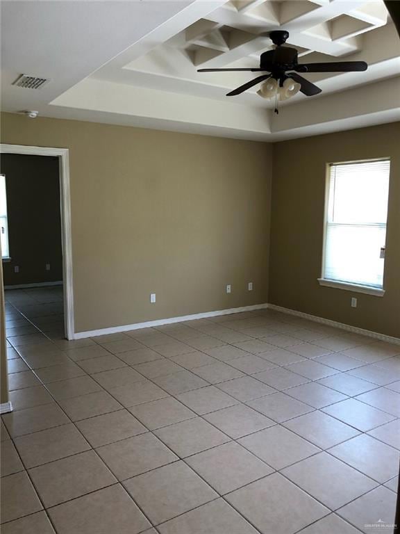 Spare room with light tile patterned flooring, a tray ceiling, a ceiling fan, coffered ceiling, and baseboards