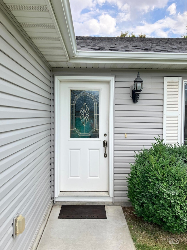 Property entrance featuring a shingled roof