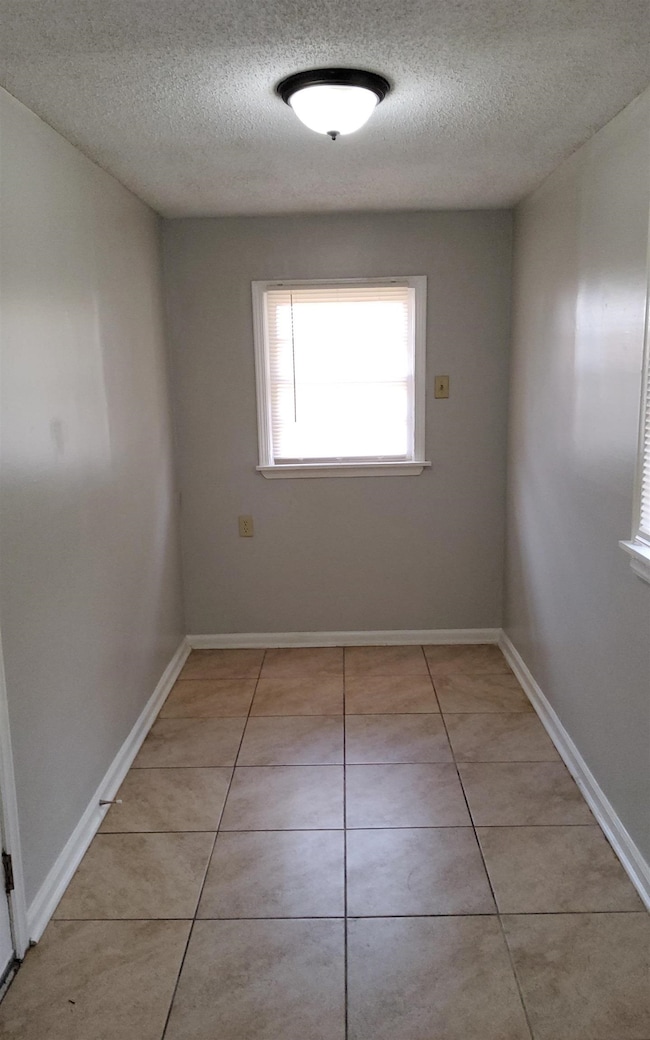Tiled spare room with a textured ceiling
