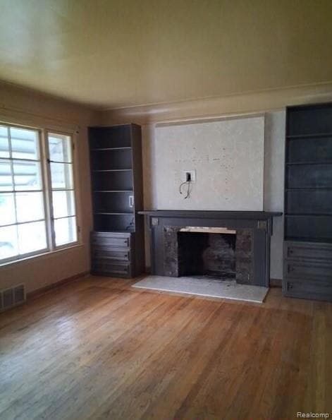 Unfurnished living room with a fireplace and wood finished floors