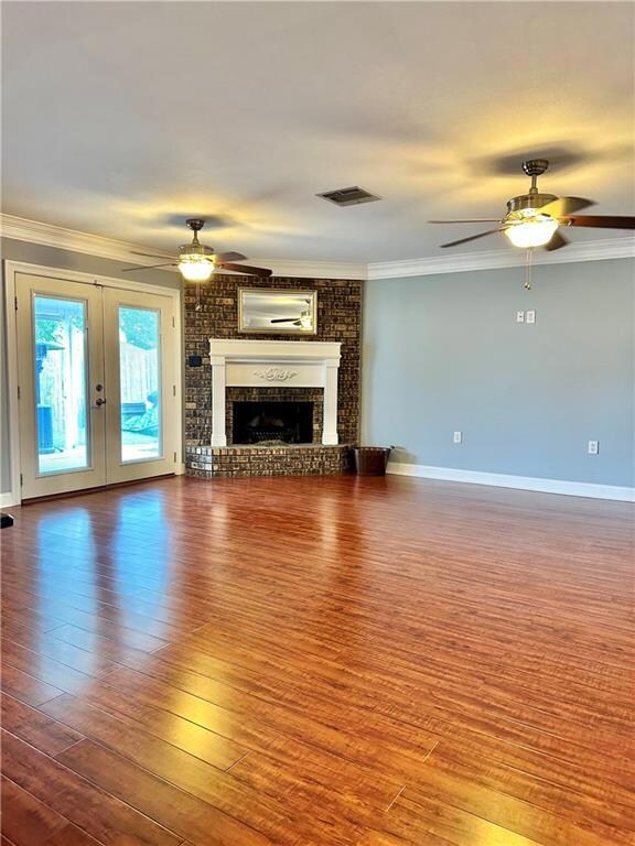 Open den with fireplace, French doors to covered p