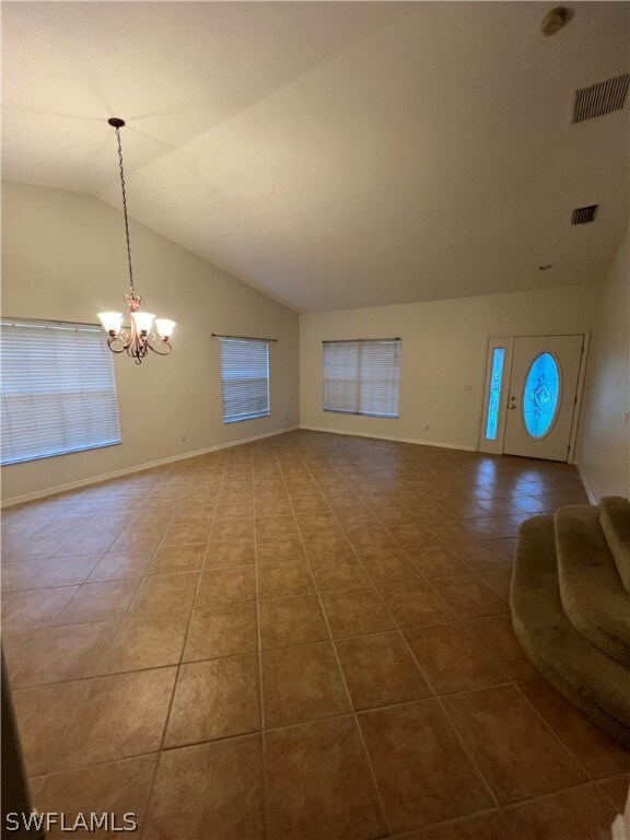 Unfurnished living room with tile flooring, vaulte