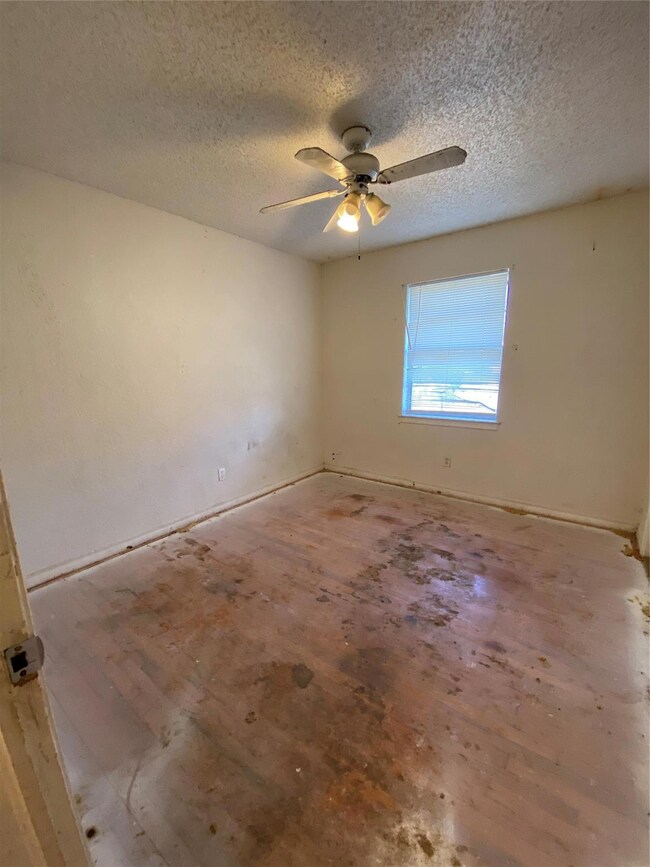 Spare room featuring ceiling fan and a textured ce