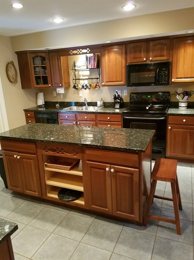 Cherry cabinets, black granite counters, center is