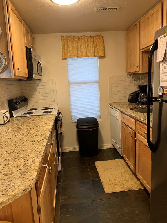 Kitchen with stove, fridge, dishwasher, baseboards