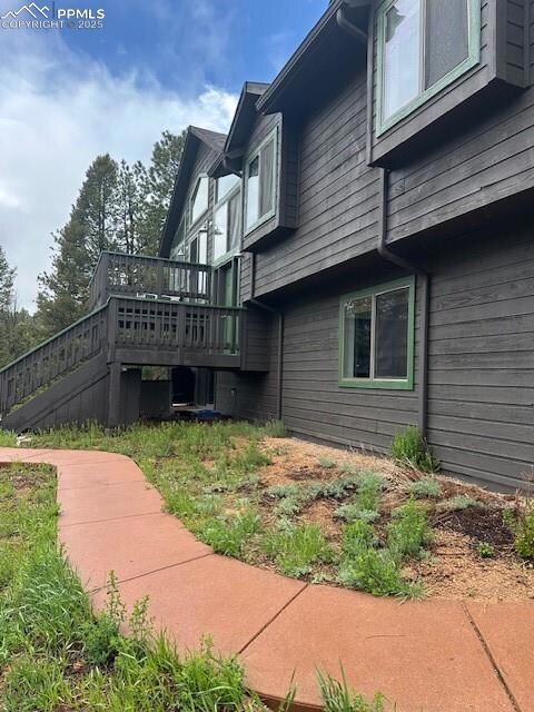 View of home's exterior with a wooden deck and stairway