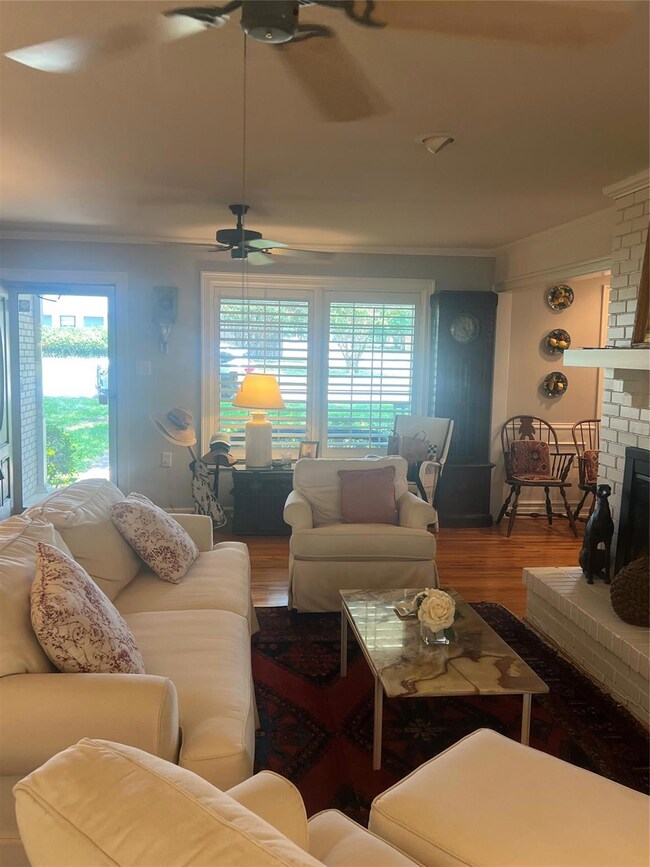 Living room featuring brick wall, wood-type floori