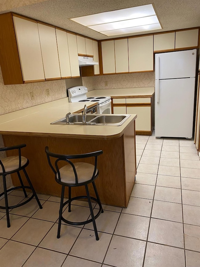Kitchen featuring light tile patterned floors, a p