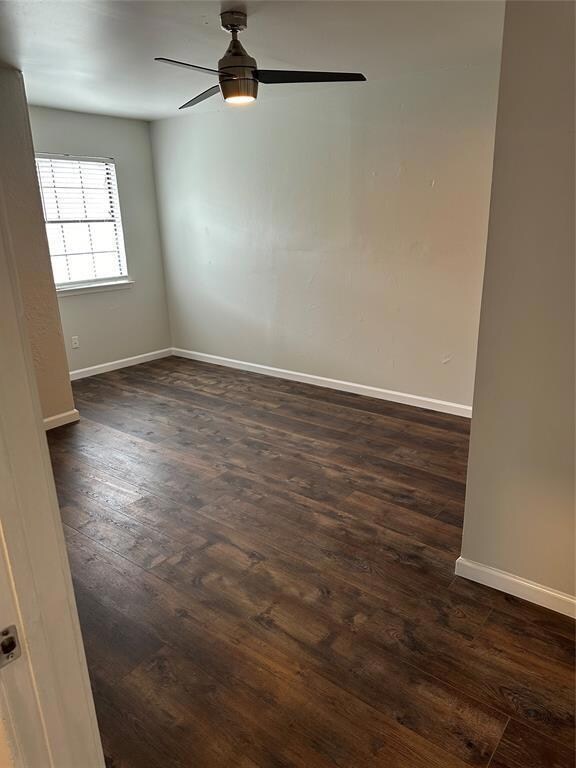Unfurnished room with dark wood finished floors and a ceiling fan
